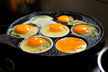 7 frying egg on frying pan on dark background.