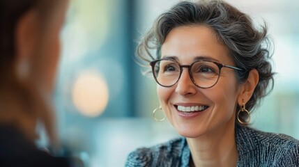 Fototapeta premium Two women having a conversation, one wearing glasses