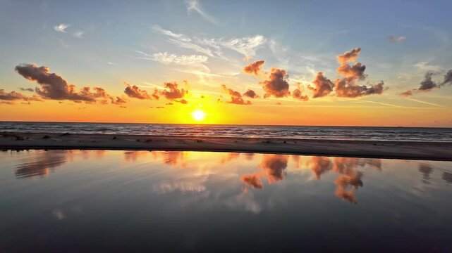 Static view of sunset with orange sunrays scattering all over the sky in Irbes Ieteka, Kempings, Latvia.