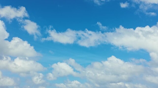 Vertical pan from blue sky and clouds down to sand, looking from Daymers Bay out to Stepper Point and Trebetherick Point