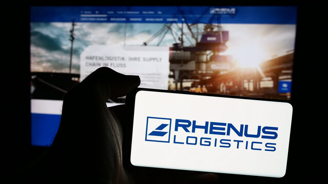 Stuttgart, Germany - 08-01-2024: Person holding mobile phone with logo of German logistics company Rhenus SE Co. KG in front of business web page. Focus on phone display.
