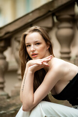 Young woman with long hair black jacket and white trousers street style