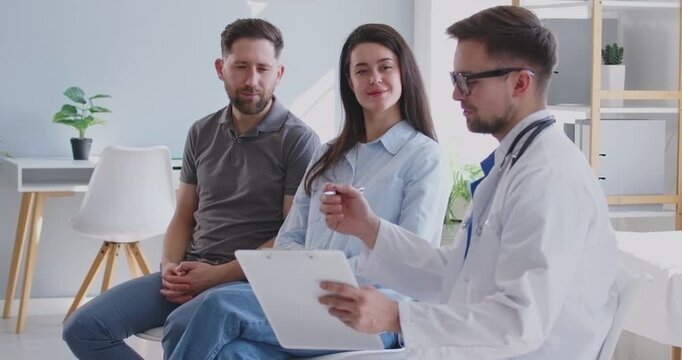 Gynecologist doctor talking to family couple during a consultation on pregnancy planning or IVF in a hospital office. Couple happy and engaged, receiving expert care and guidance for family planning.