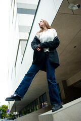 Young woman with long hair black jacket and white trousers street style