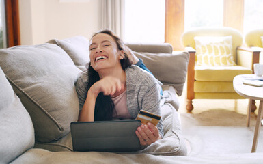Woman, home and laughing on tablet with debit card on sofa for online shopping, payment and saving...
