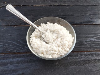 Food ingredient coarse table salt in spoon on the wooden table 