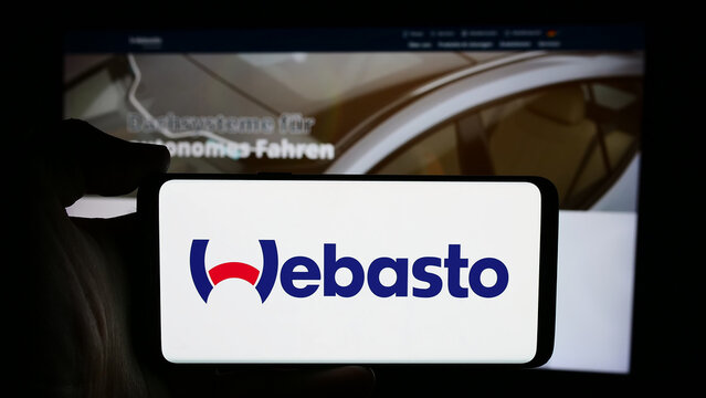 Stuttgart, Germany - 08-05-2024: Person holding cellphone with logo of German automotive company Webasto SE in front of business webpage. Focus on phone display.