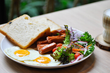 breakfast or bread with sunny side up egg, sausage and vegetable and hot coffee