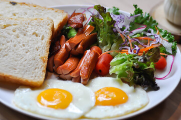 breakfast or bread with sunny side up egg, sausage and vegetable and hot coffee