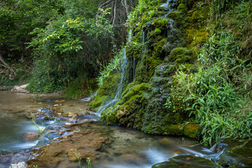 Beautiful Calicanto waterfall in Tormón, Teruel, Aragon, Spain, with double waterfall over emerald green water with daylight