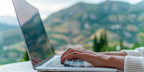 woman's hands typing on laptop computer with mountain view, working remotely, freelance, digital nomad, outdoor office