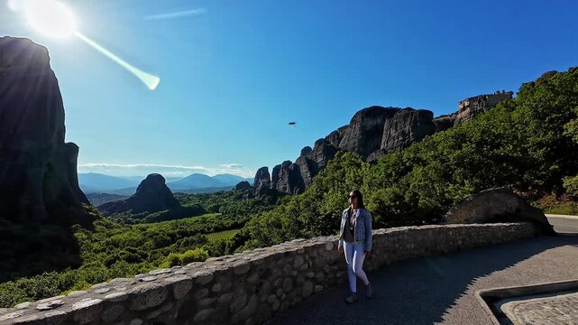 Shot of a tourist girl in sunglasses loitering around Meteora in Greece on a sunny day.