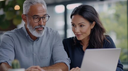 Fototapeta premium a man and woman looking at a laptop