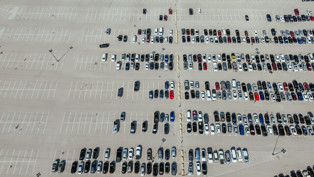 Large outdoor parking lot with parallel parking pattern and busy vehicles parked under sunny weather, Arlington, Texas, parking number, parking management in metropolitan urban area, aerial view