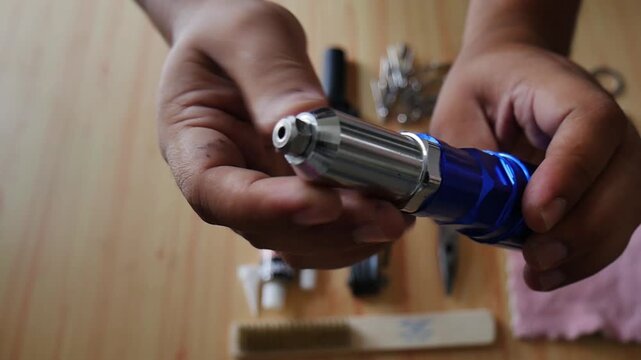 Hand holding a blue steel rivet gun adapter for drill machine