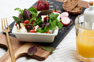 Fresh ruccola, red basil salad with balsamic vinegar and a glass of orange juice
