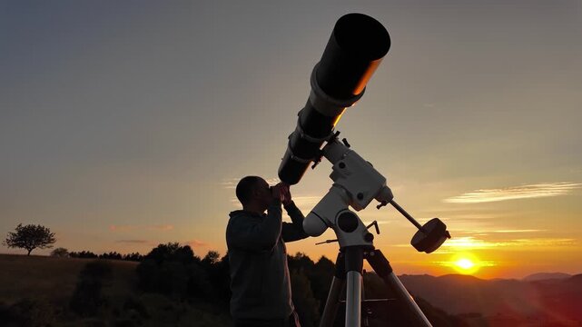 Amateur astronomer looking at the evening skies, observing planets, stars, Moon and other celestial objects with a telescope just before sun down.	
