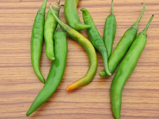 green chili peppers on wooden background, copy space, selective focus 