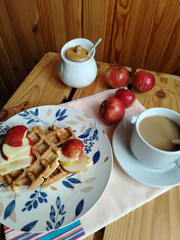 Belgian waffles with apples and honey on  wooden background. Homemade healthy breakfast. Selective focus