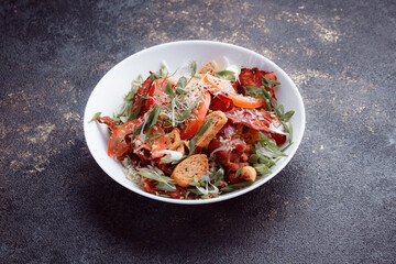 Salad panzanella of tomatoes and paper with fresh greens. Fresh vegetable mix at dark table. Top view, Copy space.