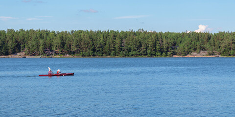 Father and son together, family activity by kayaking in the archipelago, canoeing, boating in the Baltic sea during summer vacations in Finland