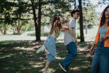 Young teenagers enjoying a playful moment in the park, highlighting friendship, joy, and happiness through laughter and carefree enjoyment outdoors.