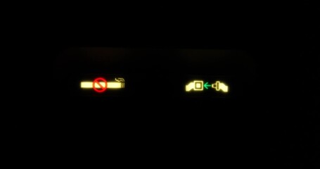 No Smoking and Fasten Seat Belts signs glowing on black monitor of commercial airplane during landing. Visual warning for passengers of jet. Travel safety rules