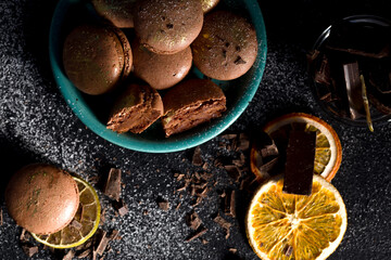 Macaroons with chocolate cream on a dark background.