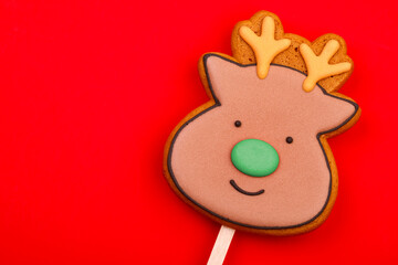 Reindeer gingerbread cookie on red background