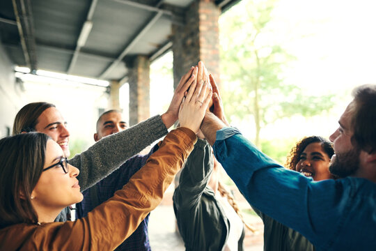 Students, group or hands together at university with support for study motivation or academic collaboration. Friends, people or diversity high five on campus for solidarity in learning or scholarship