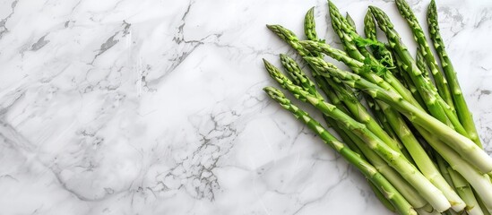 Fresh asparagus in a glass on a marble background with copy space