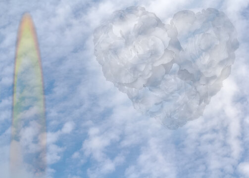 C&oelig;ur de roses blanches et flamme de bougie dans ciel bleu avec nuages 