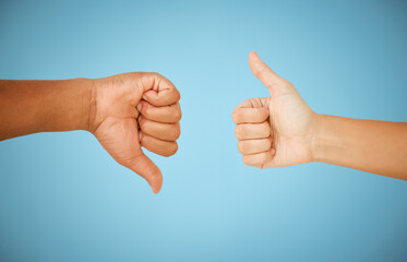 Thumbs up, people or down hand gesture with for disagreement, approval and feedback on blue background. Positive, negative and icon closeup with okay sign, dislike and conflict in studio for vote