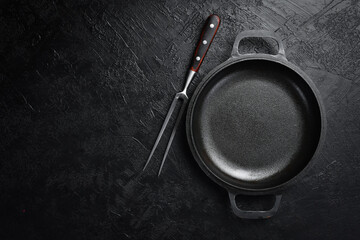Black slate background with metal pan. Free space for text. Top view.