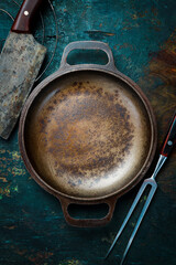 Vintage cast iron cooking pan. On a rustic background.
