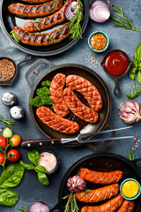 Banner with sausages for grill or barbecue. Top view. On a gray slate background.