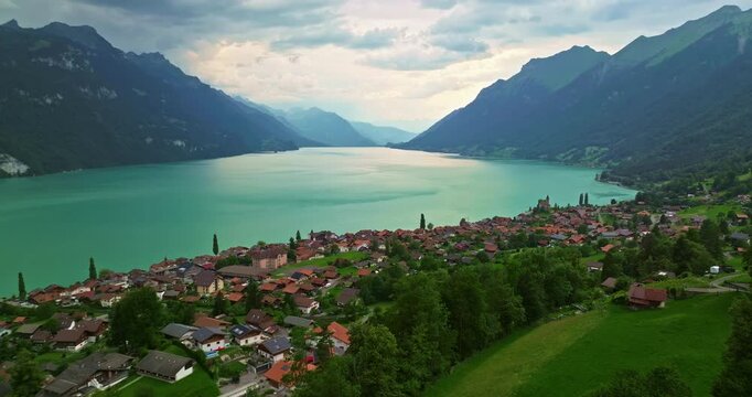 Drone flying over beautiful lake. Aerial drone swiss Alps. Swiss Alps mountain peaks and lake. Switzerland summer tourism destination. Incredible landscape of mountains and Lake Interlaken