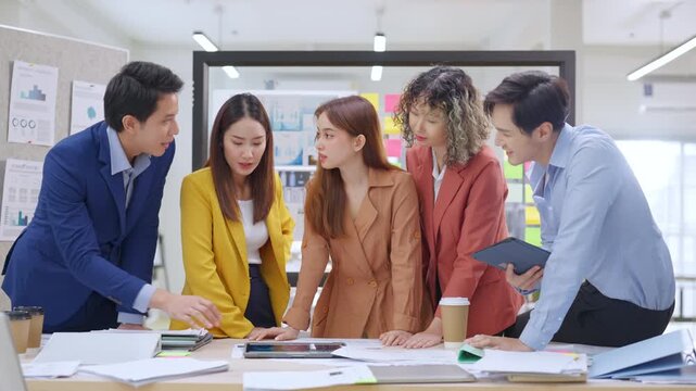 Modern office with an Asian business team sharing creative ideas. Collaborative professionals brainstorming strategies in a sleek, innovative environment, promoting teamwork and diversity