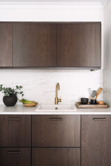 Faucet over sink built in marble countertop with local farm vegetables and kitchenware on kitchen table