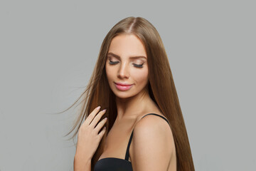 Fototapeta premium Cheerful female model brunette with long hair and natural make-up posing isolated on white background