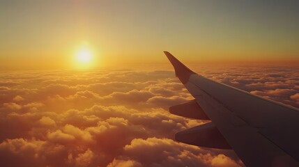 Airplane wing above clouds, golden hour sunset, panoramic view, sea of clouds, vibrant orange and pink sky, aerial photography, high altitude perspective.
