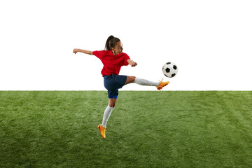 Athletic young woman, skilled bombardier, kicking ball with leg in mid-air aiming straight at opponent's goal green grassed stadium. Concept of women and sport, team games, tournament, victory, action