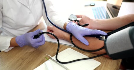 Doctor therapist measuring blood pressure on patient forearm closeup 4k movie slow motion. Prevention and treatment of arterial hypertension concept
