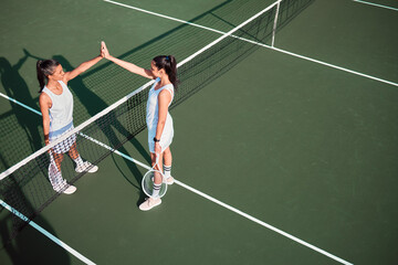 Court, tennis and women with high five for sports, competition and game challenge with thank you. Outdoor, athletes or people with hands celebration after match, training and well done for tournament