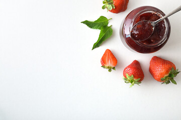 Detail of strawberry jam jar with fruit isolated on white