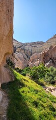 A trail between volcanic cliffs. A path between ancient rocks. Volcanic rocks. Volcanic remains. Rocks in the form of caves. 