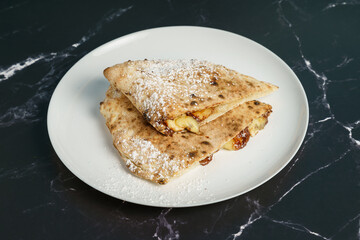 Italian dessert - calzone filled with chocolate, banana and powdered sugar