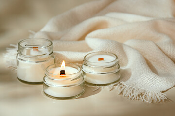 Candle With White Blanket on a Tan Surface