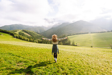 Cute woman walking green grass field, admiring landscape. Enjoying nature alone. Adventure and...