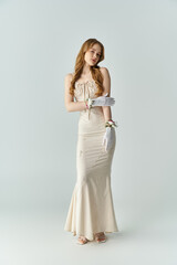 A graceful woman stands elegantly, delicate flowers on gloves.